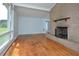 Living room with hardwood floors, brick fireplace, and large windows at 5617 Laurel Crest Dr, Durham, NC 27712