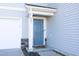 Blue front door with a welcoming mat and stone accents at 601 Joe Gibson Dr, Gibsonville, NC 27249