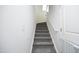 Gray carpeted staircase with white walls and a safety gate at 601 Joe Gibson Dr, Gibsonville, NC 27249