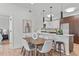 Bright dining area with modern wood table and seating next to a chef's kitchen with stainless appliances at 615 W Peace St # 307, Raleigh, NC 27605