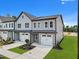 Beautiful two-story townhome with gray siding, white trim, manicured lawn and two-car garage on a sunny day at 712 Jamescroft Way # 26, Rolesville, NC 27571