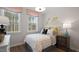 This bedroom features natural light from two windows, as well as a side table and decor at 10519 Pleasant Branch Dr # 43, Raleigh, NC 27614