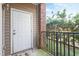 Cozy balcony with a white door, brick accent, and a view of lush greenery at 2621 Oldgate Dr # 105, Raleigh, NC 27604