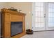 Close up of electric fireplace and french doors, with pine cones in basket at 2621 Oldgate Dr # 105, Raleigh, NC 27604