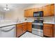 Kitchen area featuring wood cabinets, stainless steel appliances, and tiled backsplash at 2621 Oldgate Dr # 105, Raleigh, NC 27604