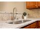 Close up of the kitchen sink highlighting granite countertops, tiled backsplash, and brushed nickel faucet at 2621 Oldgate Dr # 105, Raleigh, NC 27604