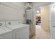 Laundry area with washer, dryer, hot water heater, and kitchen doorway at 2621 Oldgate Dr # 105, Raleigh, NC 27604