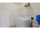 A compact laundry room with a stacked washer and dryer, plus storage shelf at 2621 Oldgate Dr # 105, Raleigh, NC 27604