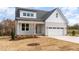 Charming two-story home with gray siding, white trim, a two-car garage, and a manicured front lawn at 57 Nottoway Ln, Wendell, NC 27591