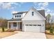 Charming two-story home with gray siding, white trim, a two-car garage, and a manicured front lawn at 57 Nottoway Ln, Wendell, NC 27591