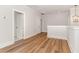 Bright hallway with wood floors, neutral paint, and an open doorway leading into another room at 57 Nottoway Ln, Wendell, NC 27591