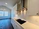 Modern kitchen featuring stainless steel range hood, white cabinets, and quartz countertop at 57 Nottoway Ln, Wendell, NC 27591