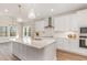 Bright kitchen featuring a large island, white cabinetry, quartz counters, and stainless steel appliances at 57 Nottoway Ln, Wendell, NC 27591