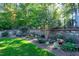 Landscaped backyard with stone wall and lush greenery at 5904 Bellona Ln, Raleigh, NC 27612