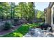 Landscaped backyard with patio and grill, surrounded by trees at 5904 Bellona Ln, Raleigh, NC 27612