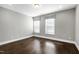 Simple bedroom with dark hardwood floors and window coverings at 5904 Bellona Ln, Raleigh, NC 27612