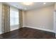Bright bedroom featuring hardwood floors and window with blinds at 5904 Bellona Ln, Raleigh, NC 27612