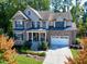 Stately two-story home boasts stone accents, manicured landscaping, a covered front porch, and an attached two-car garage at 5904 Bellona Ln, Raleigh, NC 27612