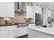 Modern kitchen with white cabinets, stainless steel appliances, and quartz countertops at 5904 Bellona Ln, Raleigh, NC 27612