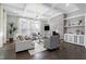Bright and airy living room featuring a coffered ceiling, fireplace, built-in shelves, and large windows with natural light at 5904 Bellona Ln, Raleigh, NC 27612