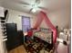 Cozy bedroom with a daybed, desk, and pink canopy at 6908 Park Pl, Raleigh, NC 27616