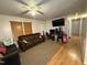 Living room with hardwood floors, brown sofa and a large TV at 6908 Park Pl, Raleigh, NC 27616
