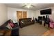 Living room features hardwood floors, brown sofas, and large TV at 6908 Park Pl, Raleigh, NC 27616