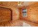 Spacious bedroom with wood walls, floors, and a window at 7440 Stockard Rd, Snow Camp, NC 27349