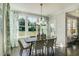 Well-lit dining room featuring a rustic wood table, modern chandelier, and large windows with green view at 90 Demascus Way # 024, Four Oaks, NC 27524