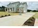 Long concrete driveway leading to a well-maintained two-story home with an attached garage at 90 Demascus Way # 024, Four Oaks, NC 27524