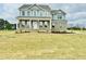 Charming two-story home featuring a welcoming front porch and beautifully landscaped yard at 90 Demascus Way # 024, Four Oaks, NC 27524
