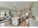 Open concept kitchen with hardwood floors, an island, stainless steel appliances, and a view of the living room at 90 Demascus Way # 024, Four Oaks, NC 27524