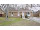 Brick ranch house with a front yard, driveway, and wooden fence at 915 Da Vinci St, Durham, NC 27704