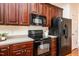 Modern kitchen with dark wood cabinets and black appliances at 105 Danesway Dr, Holly Springs, NC 27540