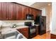 Modern kitchen with dark wood cabinets and black appliances at 105 Danesway Dr, Holly Springs, NC 27540