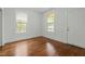 Bedroom featuring hardwood floors, bright light from the windows and a white door at 1108 Taylor St, Durham, NC 27701