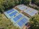 Aerial view of several well-maintained tennis courts, surrounded by lush greenery at 113 Meadowglades Ln, Cary, NC 27518