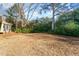 Expansive back yard featuring a screened porch, mature trees, and lush green space at 113 Meadowglades Ln, Cary, NC 27518