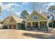 Charming home with a manicured lawn, gabled roof, wood garage doors, and inviting front porch at 113 Meadowglades Ln, Cary, NC 27518