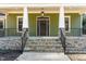 Inviting front porch with stone accents, classic columns, and an elegant hanging light fixture at 113 Meadowglades Ln, Cary, NC 27518
