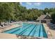 Community swimming pool with blue water, lap lanes, lounge chairs, and a clubhouse at 113 Meadowglades Ln, Cary, NC 27518