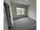 Clean room with neutral walls, carpeted floors, and a large window overlooking neighborhood at 1528 Goldfinch Perch Ln, Knightdale, NC 27545