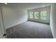 Bright bedroom with large windows and gray carpet, and white walls and trim at 1528 Goldfinch Perch Ln, Knightdale, NC 27545