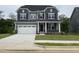 Charming two-story home with gray siding, stone accents, manicured lawn, and a two car garage at 1528 Goldfinch Perch Ln, Knightdale, NC 27545