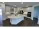 Modern kitchen with stainless steel appliances, white cabinets, island, quartz countertop, and backsplash at 1528 Goldfinch Perch Ln, Knightdale, NC 27545