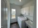 Laundry room with a white washer and dryer, utility sink, white cabinets, and wood floors at 1528 Goldfinch Perch Ln, Knightdale, NC 27545