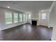 Spacious living room with dark wood floors, fireplace, and large windows with natural light at 1528 Goldfinch Perch Ln, Knightdale, NC 27545