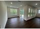 Bright room with dark wood floors, and a sliding glass door leading to the patio area at 1528 Goldfinch Perch Ln, Knightdale, NC 27545