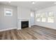 Living room with fireplace, hardwood floors, and large windows at 210 Beacon Dr, Pittsboro, NC 27312