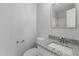 Bathroom featuring a granite countertop, white cabinet, framed mirror and a toilet at 3 Cheltenham Dr, Clayton, NC 27520